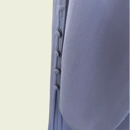 Close-up of a textured lilac fabric with stitching detail on a beige background