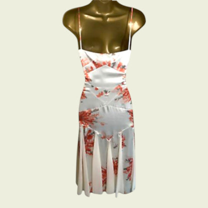 White dress with red floral pattern on a mannequin against a beige background