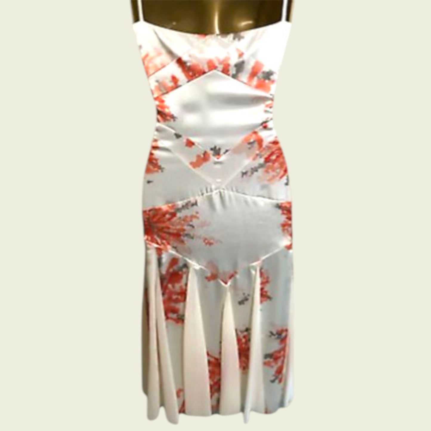 White dress with red floral pattern on a mannequin against a white background