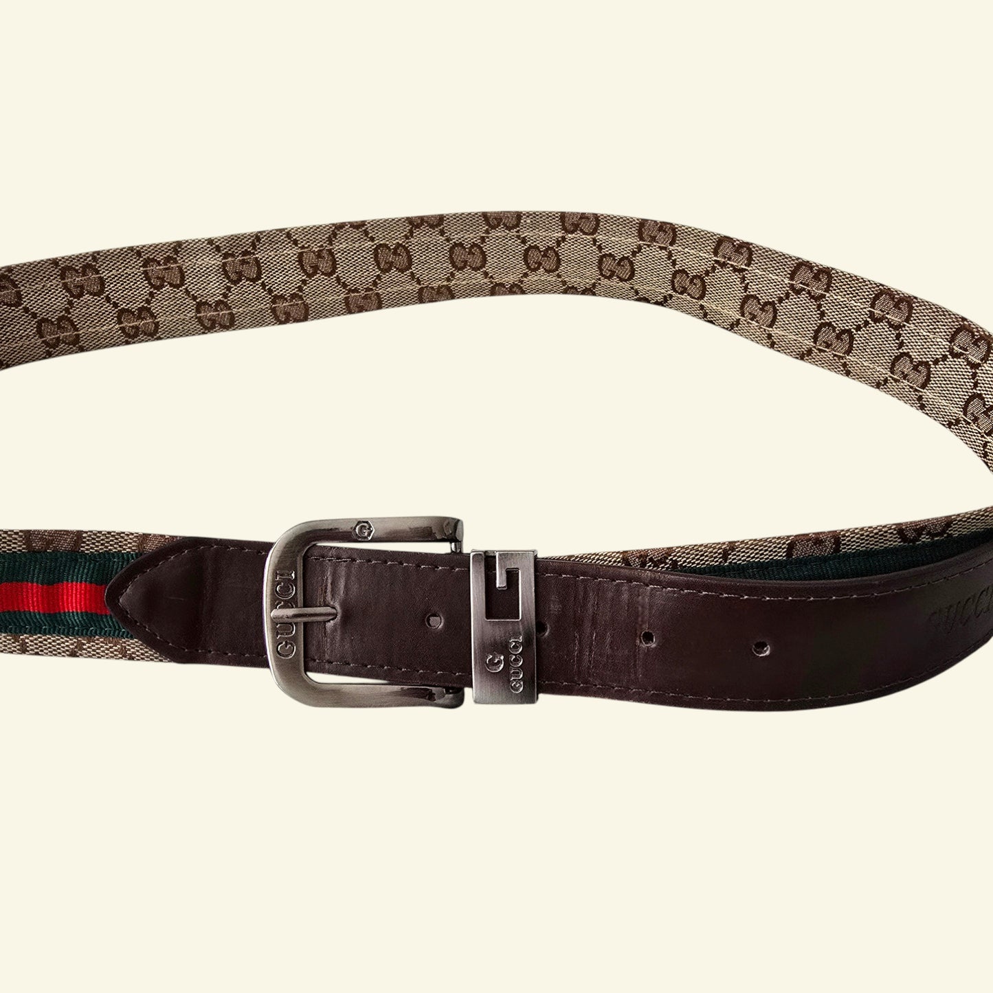Designer belt with patterned strap and metal buckle on a white background