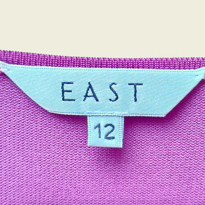 Close-up of a Fuchsia pink fabric with 'EAST' and number '12' label.