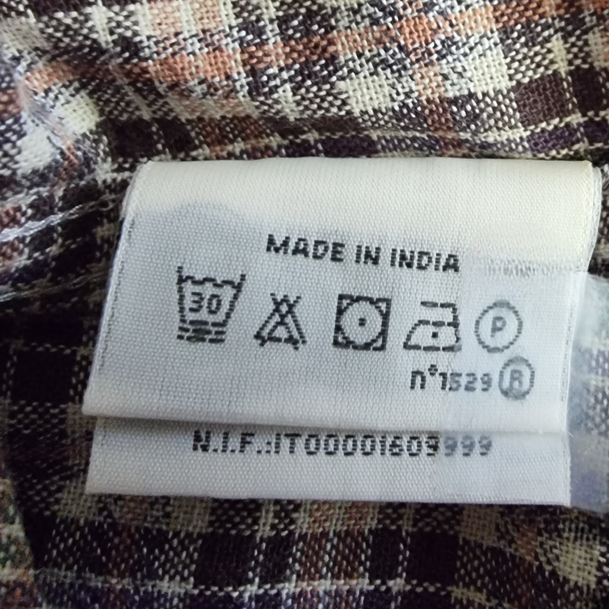 Laundry instructions on brown plaid fabric