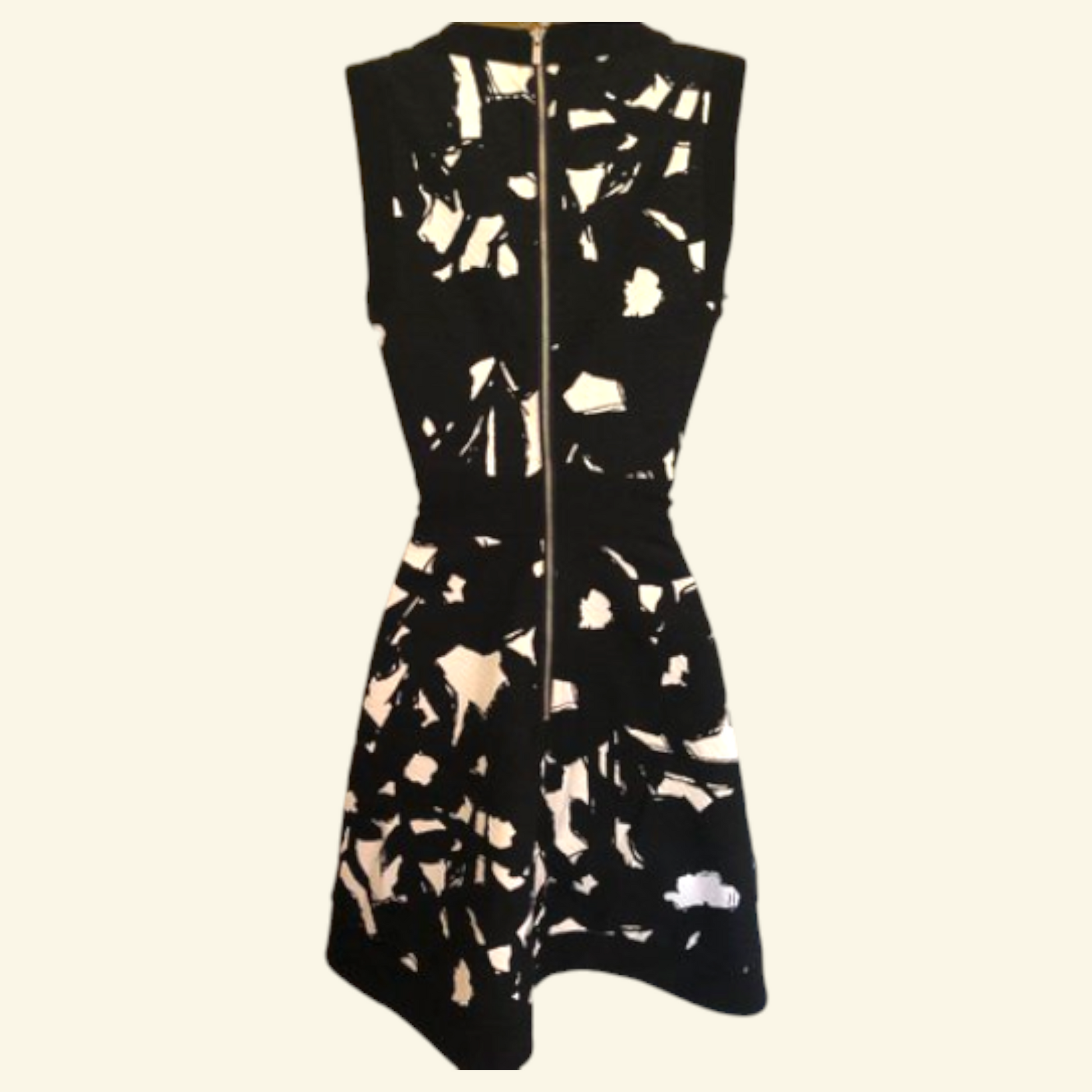 A sleeveless black dress with an abstract beige and white pattern and a front zipper, shown against a plain light background.