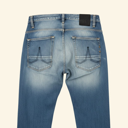Light blue denim jeans with a faded wash, laid flat against a light off-white background.