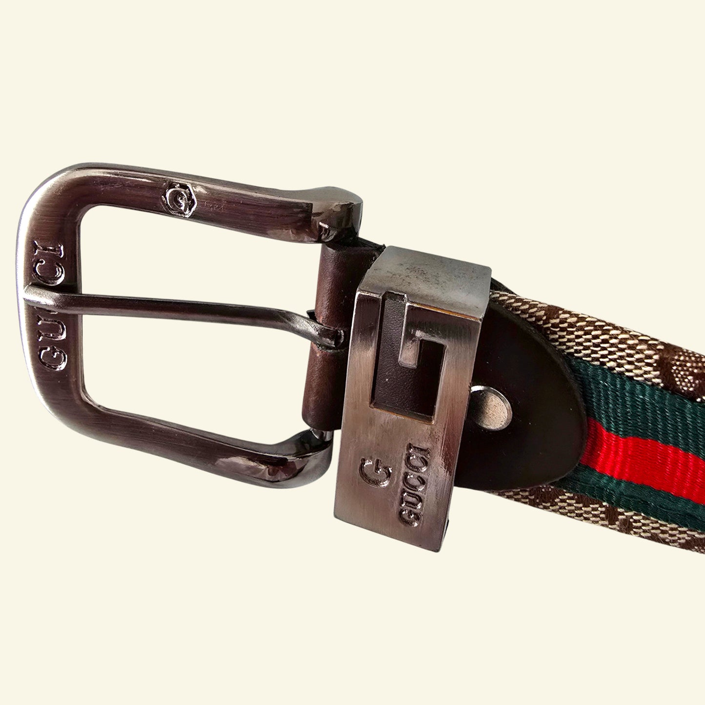 Gucci belt with web pattern and metal buckle on a white background