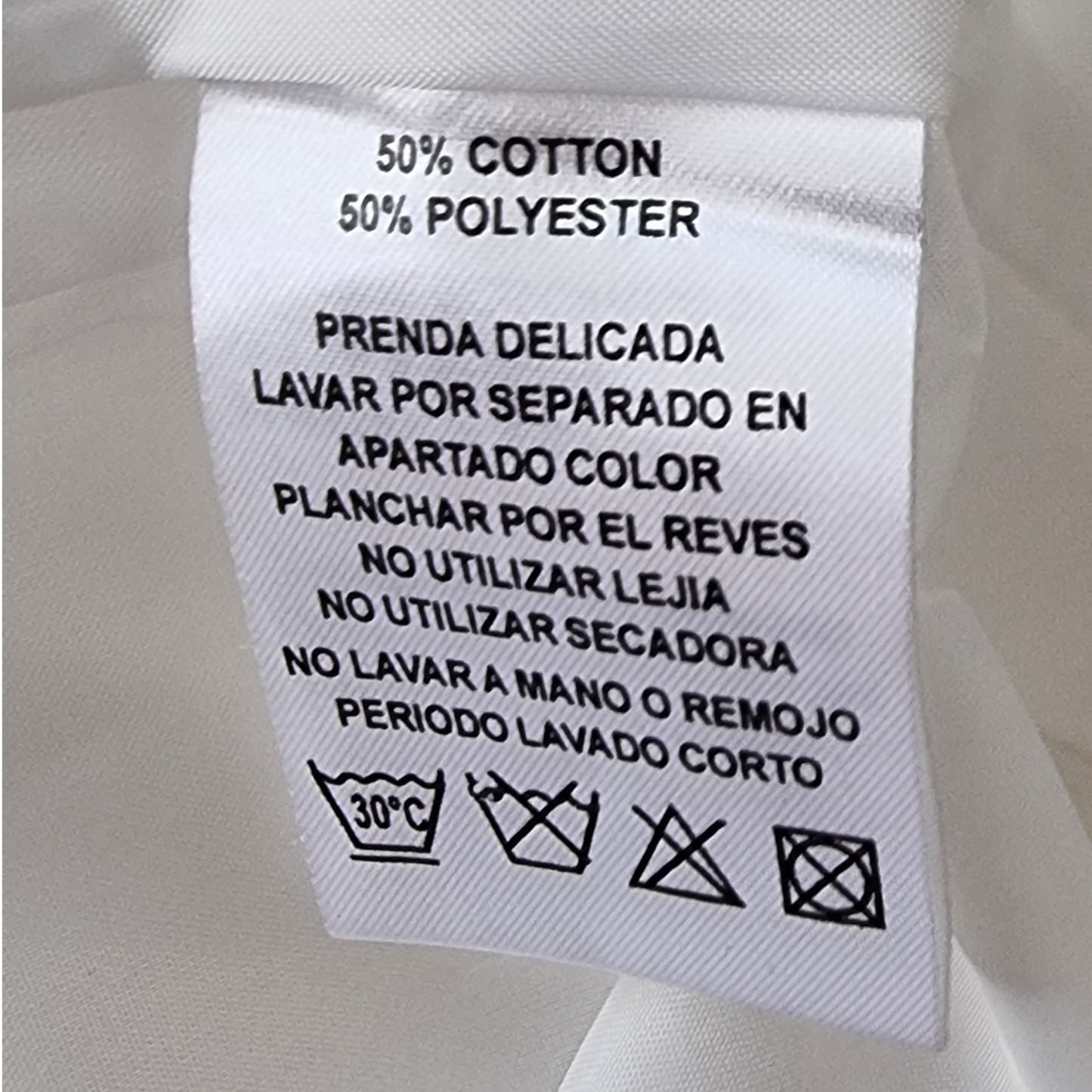 Clothing label with care instructions on a white fabric background