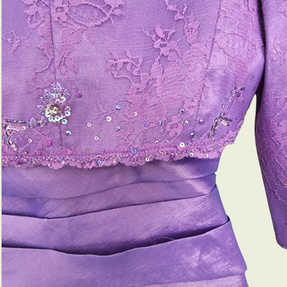 Close-up of a purple lace bolero with sequin details on a light green background