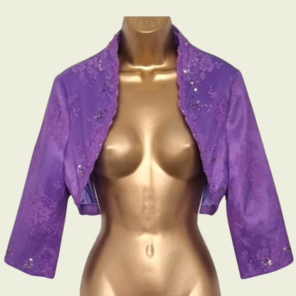 Purple lace bolero on a mannequin against a plain background