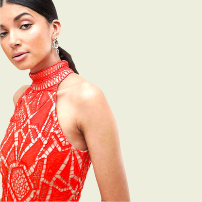 Woman wearing a red patterned top against a plain background