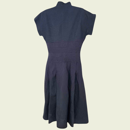 Navy blue dress with a fitted bodice and flared skirt on a beige background