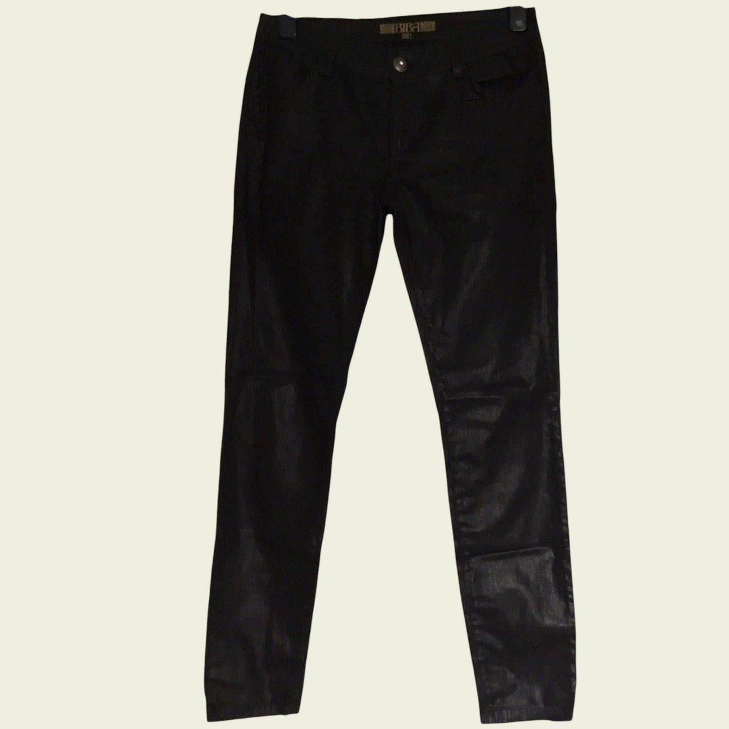 Black coated pants on a beige background