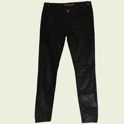 Black coated pants on a beige background