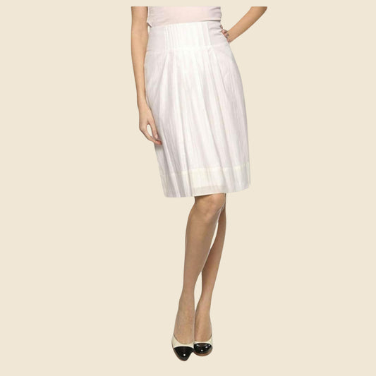 Cream pleated skirt worn by a person on a beige background