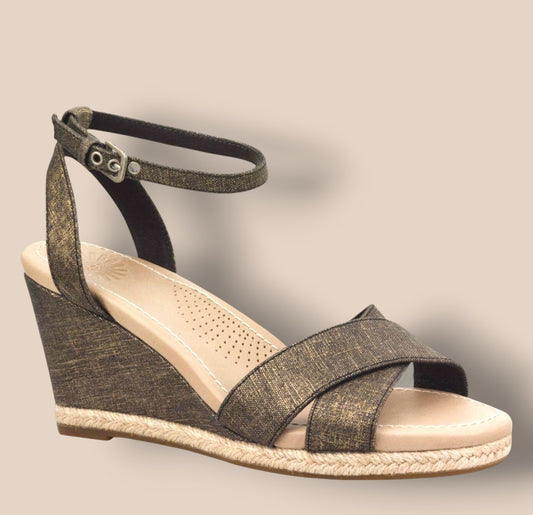 Wedge sandal with criss-cross straps on a beige background