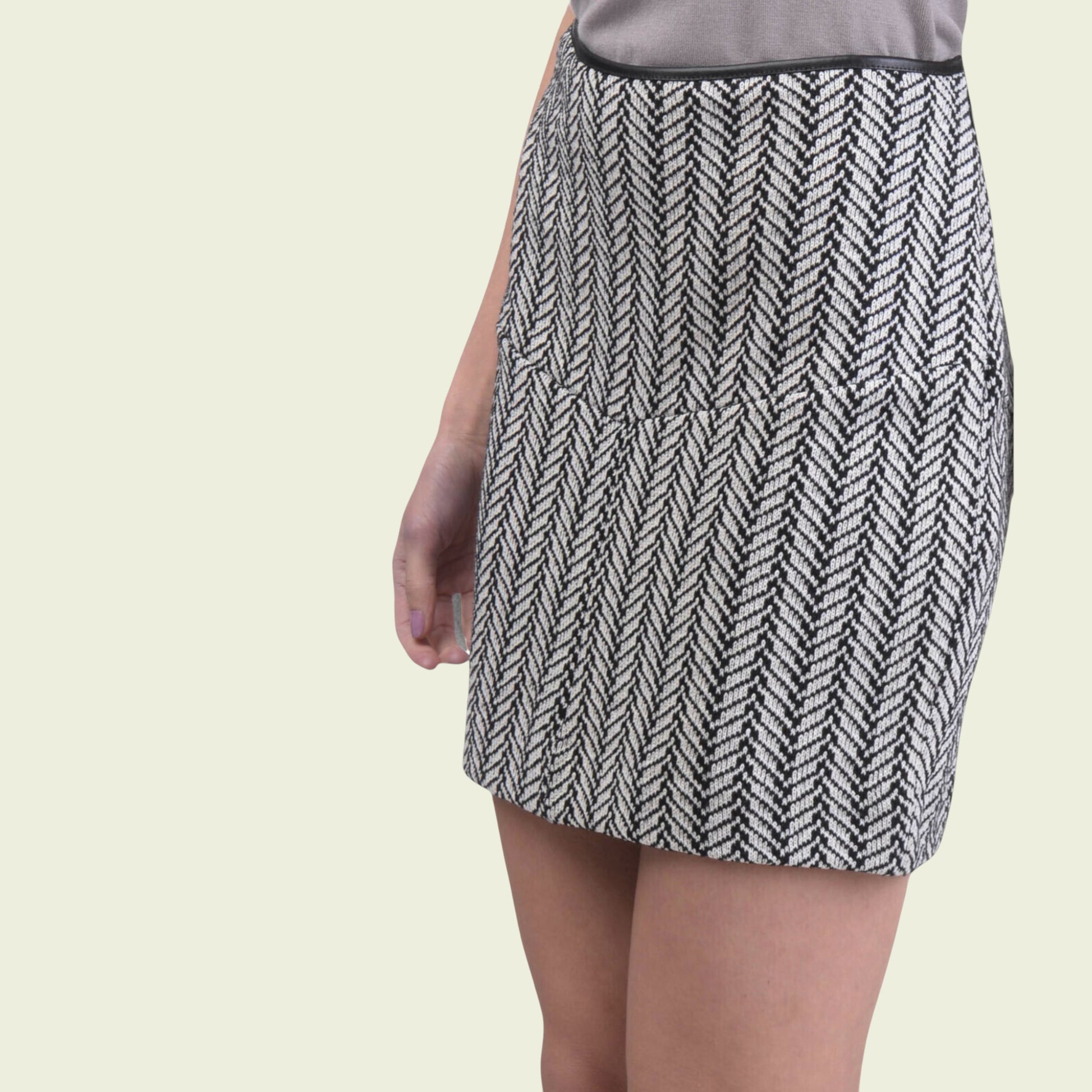 Black and white patterned skirt worn by a person on a beige background