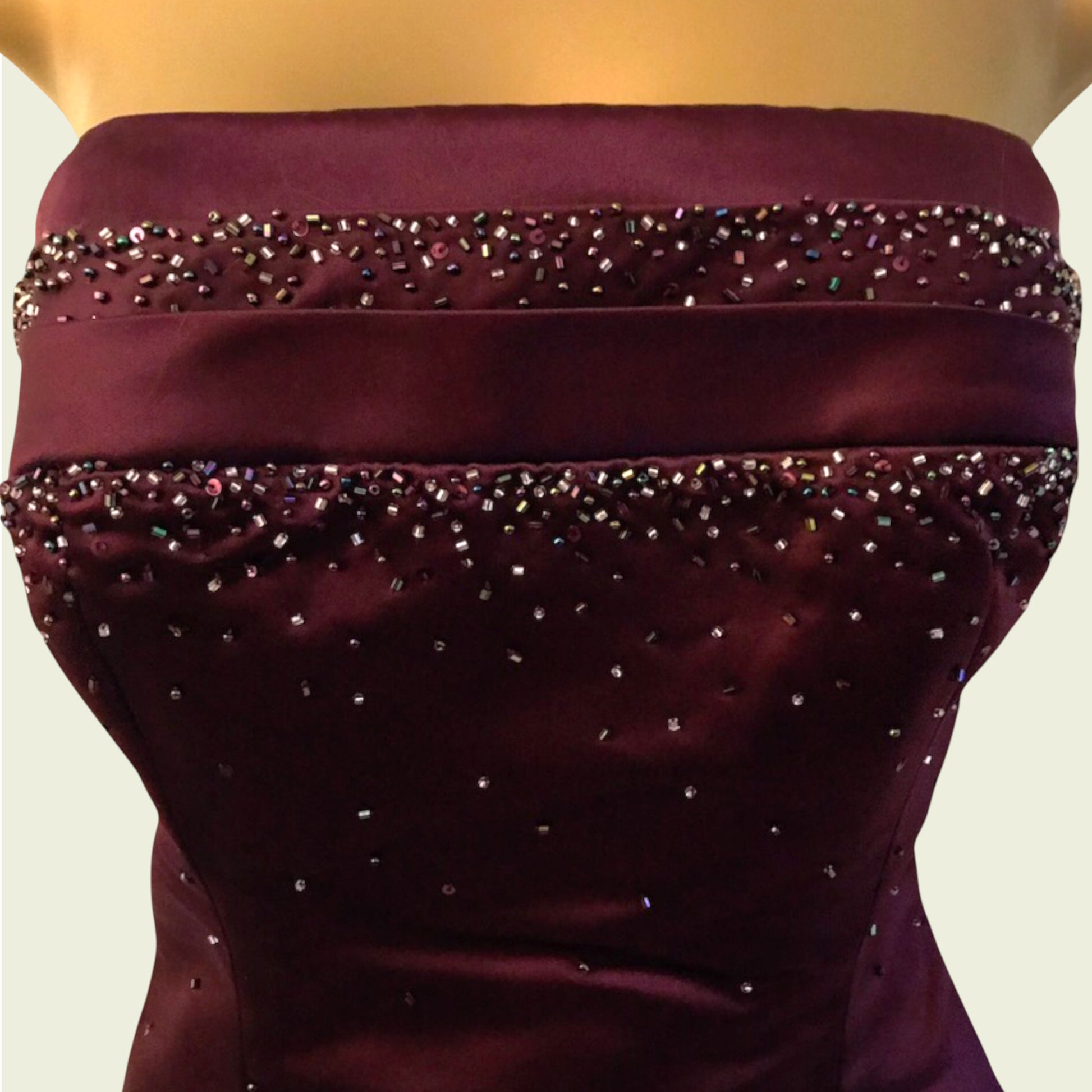 Maroon strapless dress with bead embellishments on a neutral background