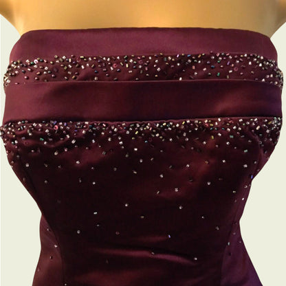 Maroon strapless dress with bead embellishments on a neutral background