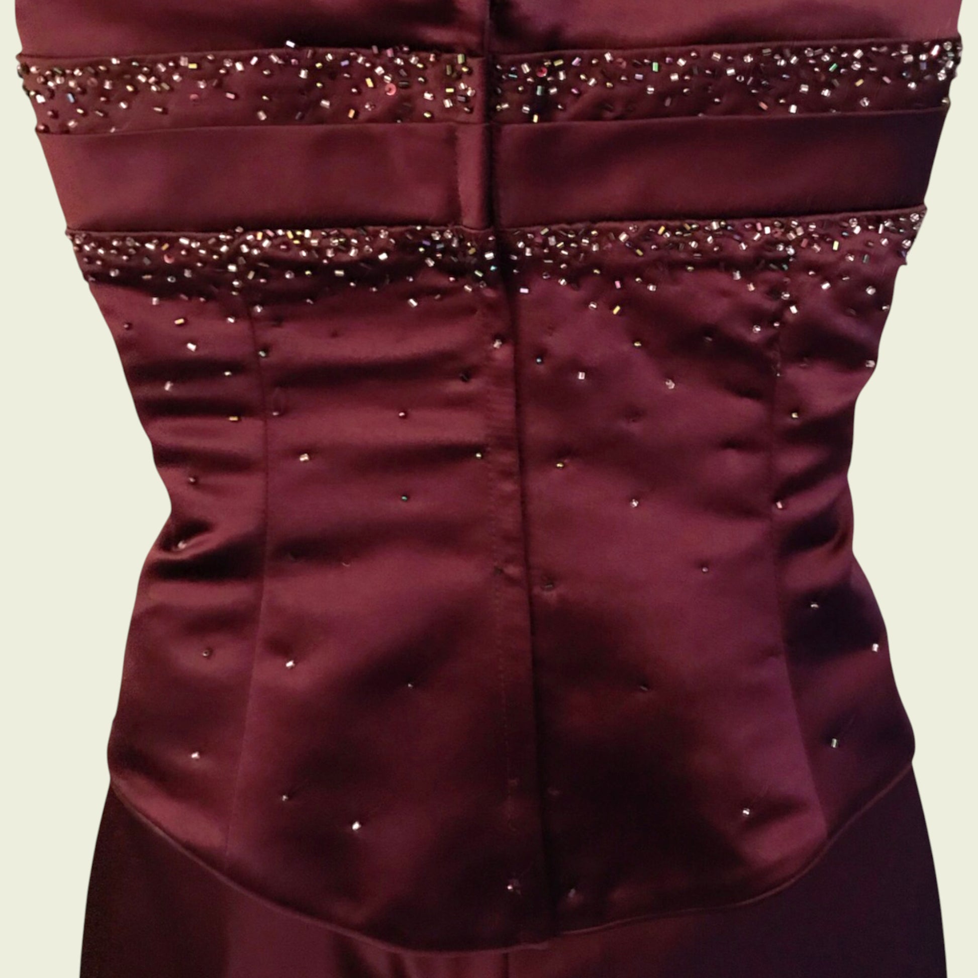 Maroon strapless dress with bead embellishments on a beige background