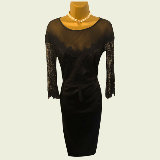Black lace dress on a mannequin with a plain background