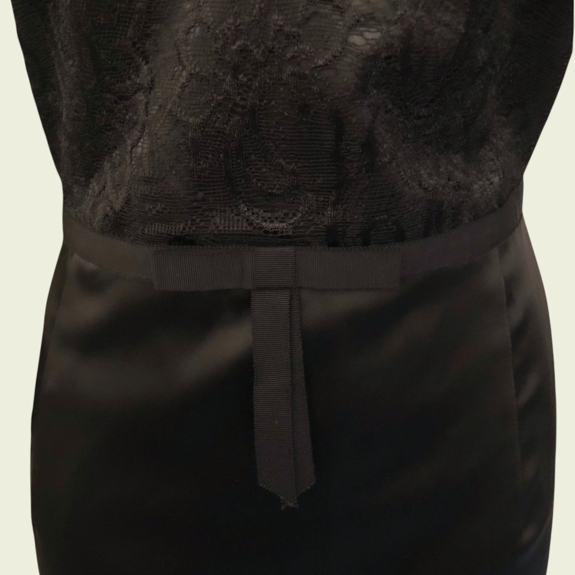 Black lace top and black skirt on a neutral background