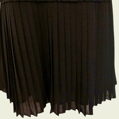 Black pleated skirt on a beige background