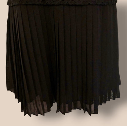 Black pleated skirt on a beige background