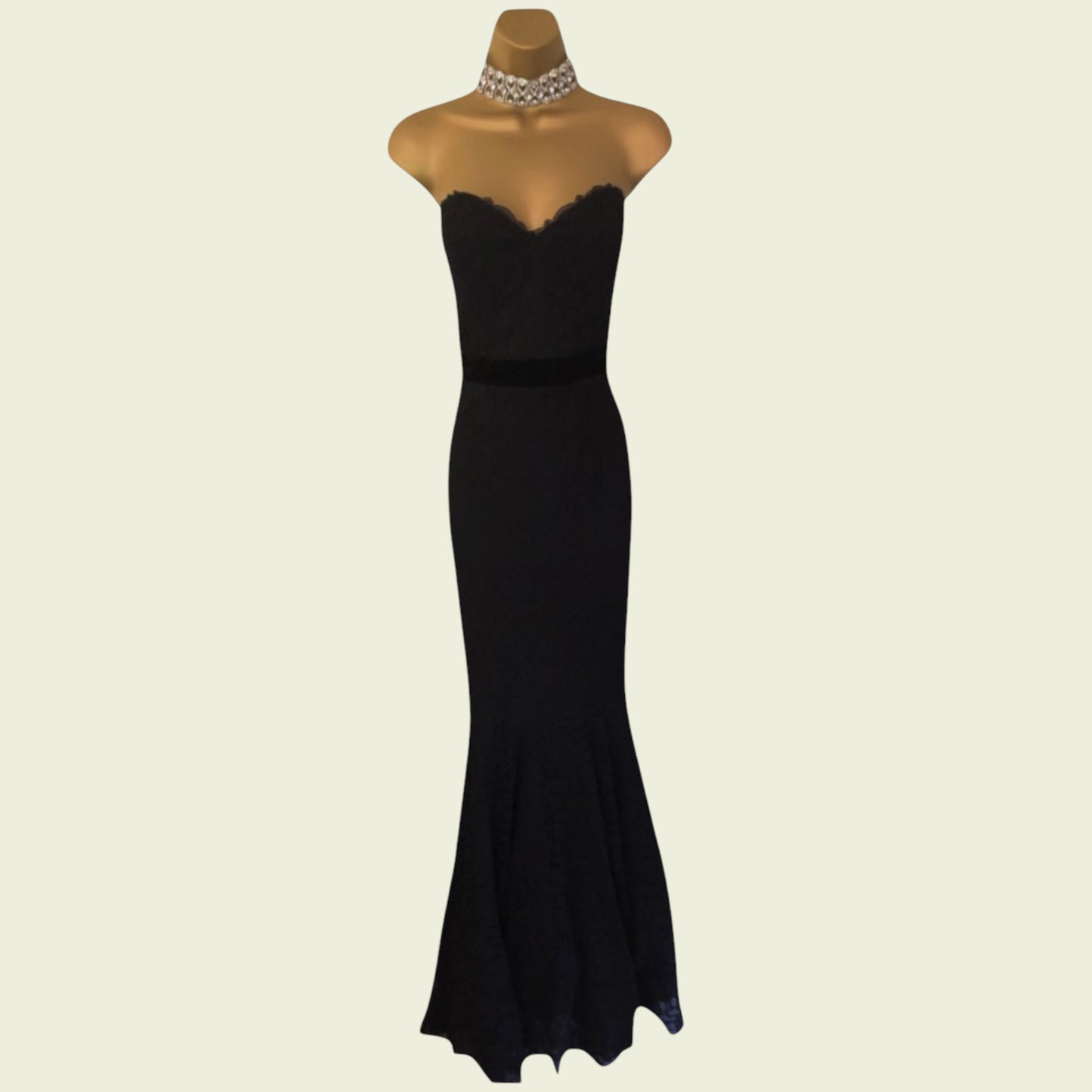 Black evening gown on a mannequin with a beige background
