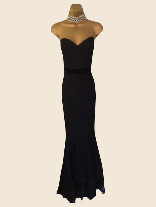 Black evening gown on a mannequin against a beige background