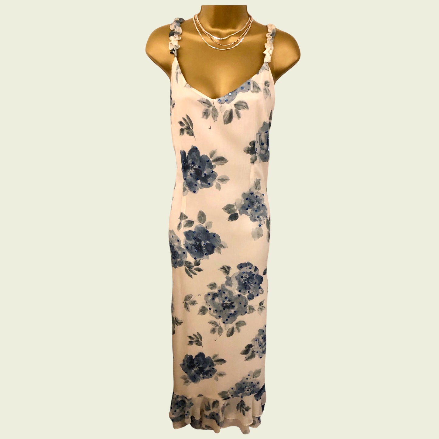 Floral dress on a mannequin against a beige background