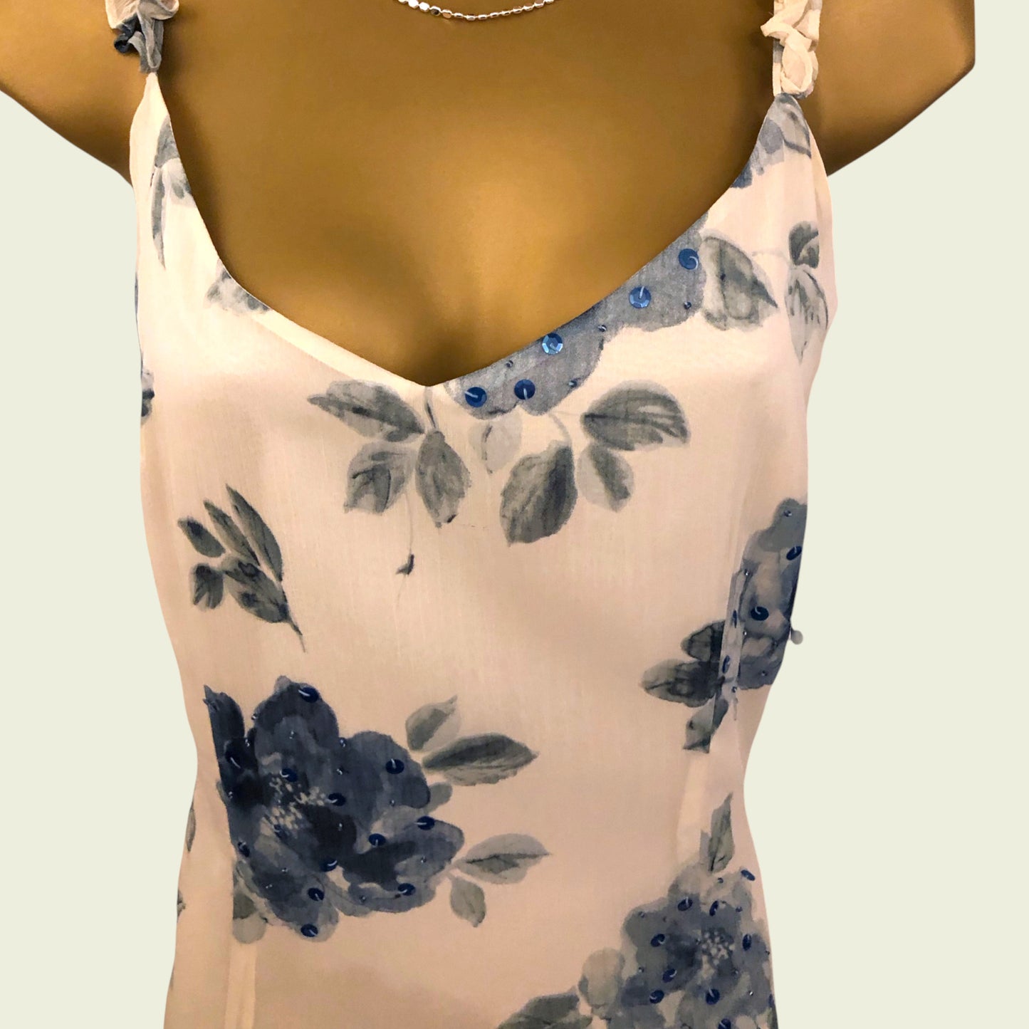 Woman wearing a floral dress with blue accents on a light background