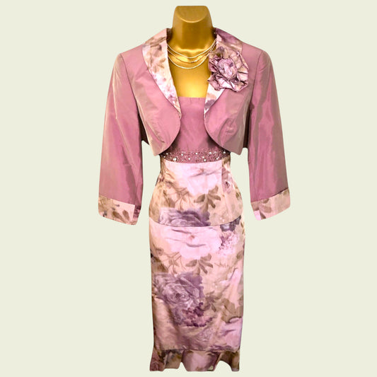 Pink floral dress with matching jacket on a mannequin against a light green background