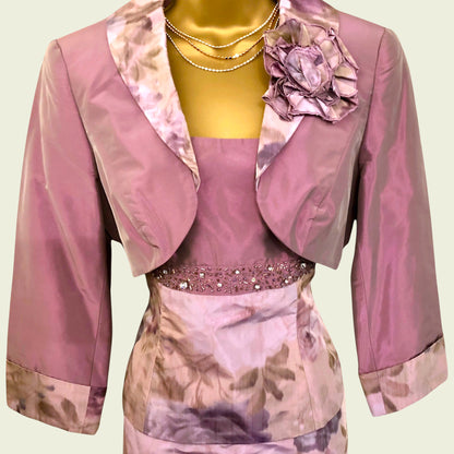 Pink floral outfit with matching jacket on a mannequin against a light green background