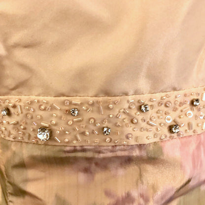 Close-up of a peach garment with decorative beads and sequins.