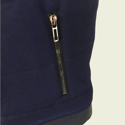 Navy blue garment with a gold zipper on a beige background