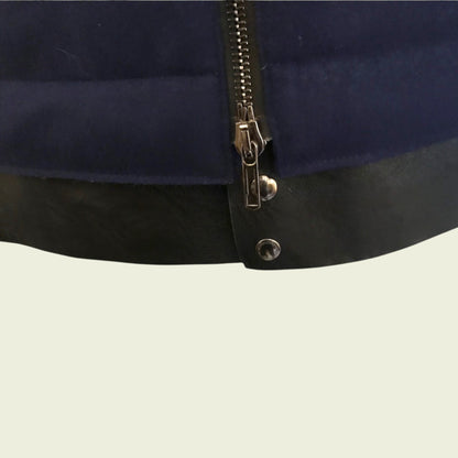 Close-up of a navy blue jacket with a zipper on a beige background