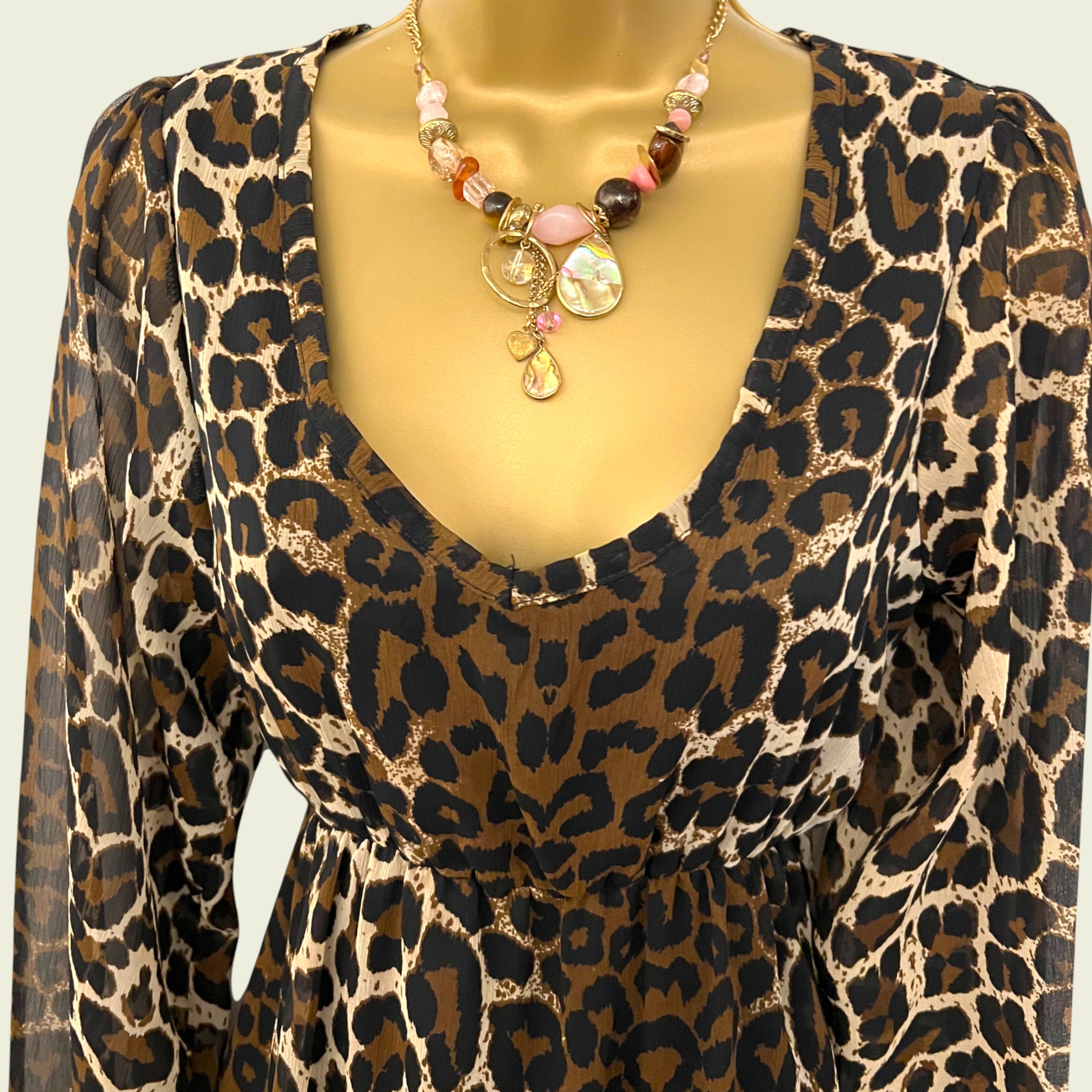 Mannequin wearing animal print chiffon dress on beige background
