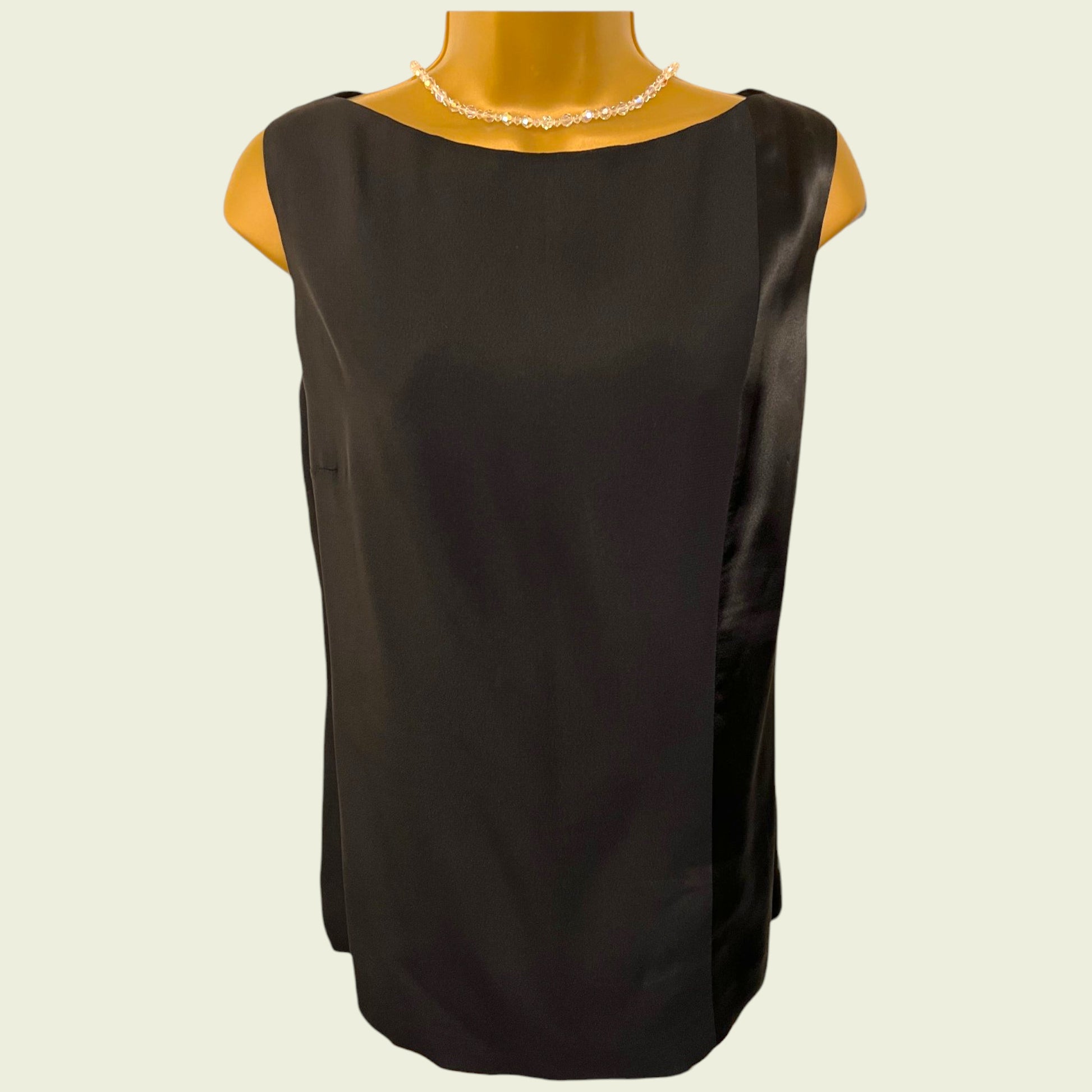 Black sleeveless top on a mannequin with a plain background