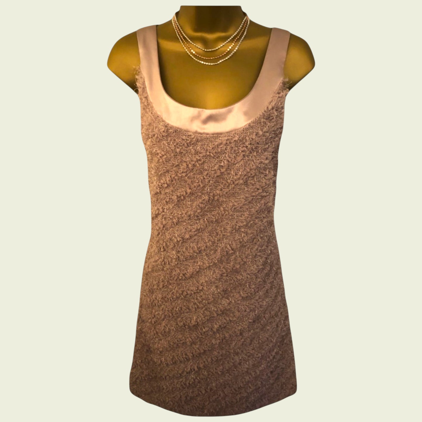 Brown sleeveless dress on a mannequin with a beige background