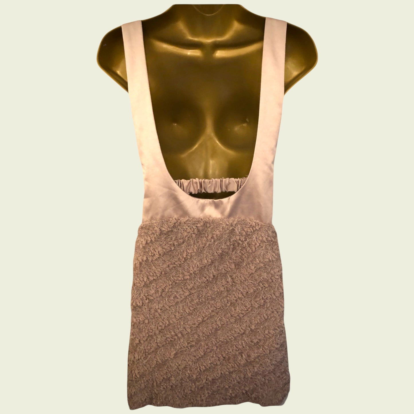 Mannequin wearing a beige dress with a textured brown bottom half on a light  background