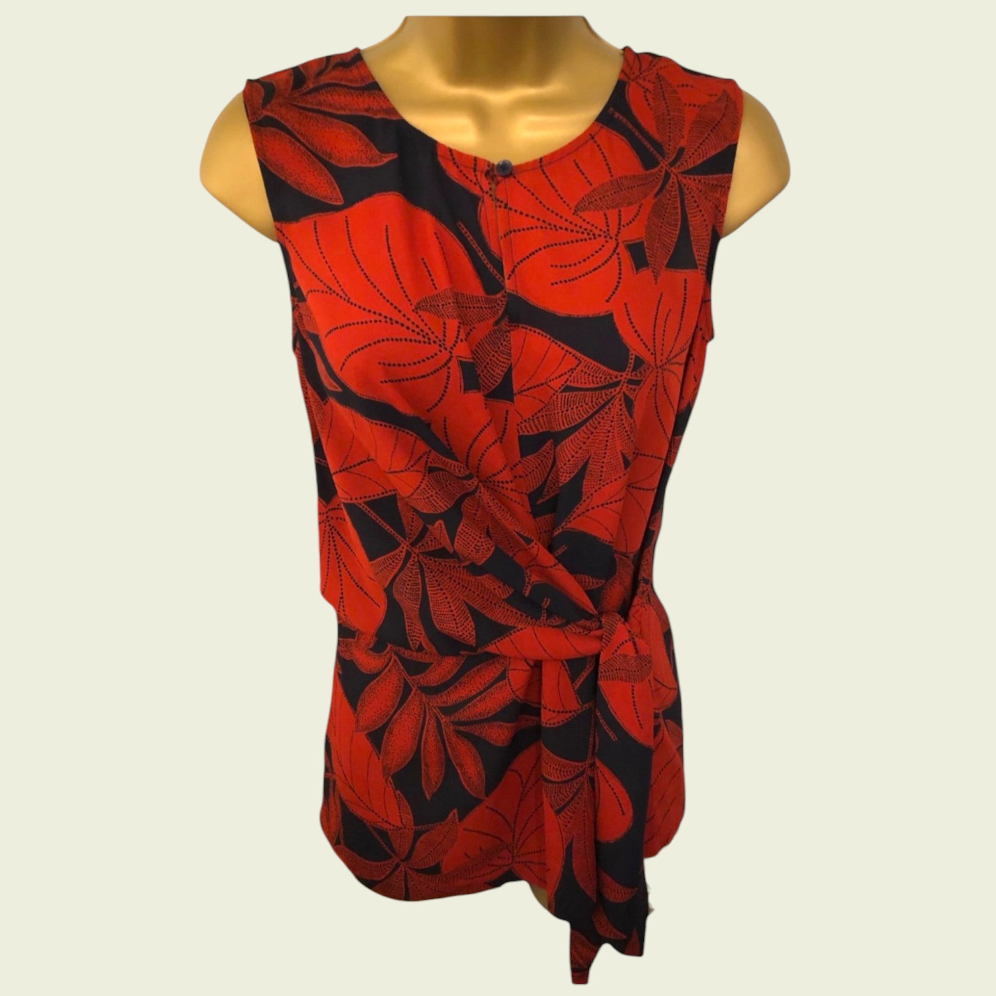 Red and black leaf-patterned top on a mannequin against a white background