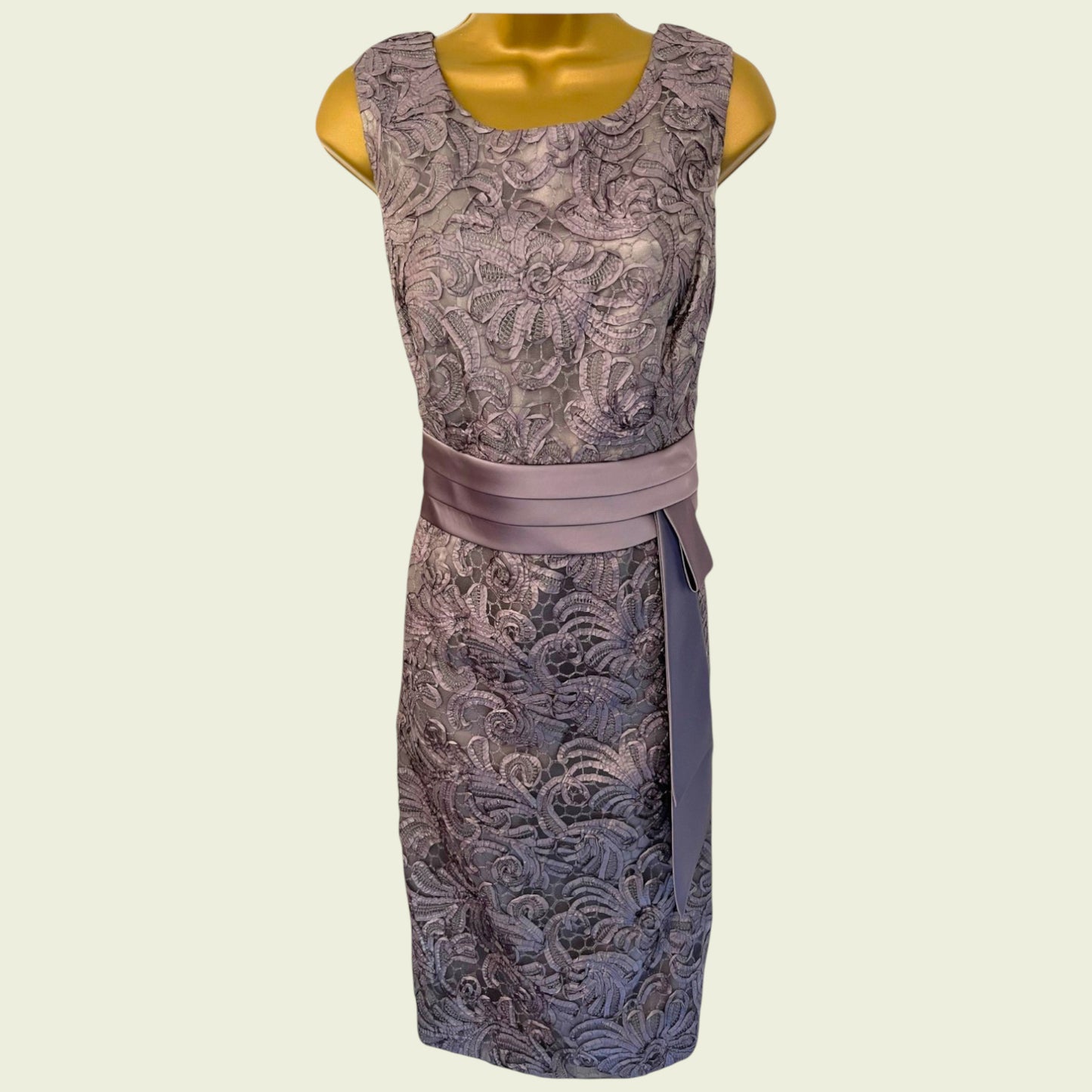 Patterned dress with a belt on a mannequin against a beige background