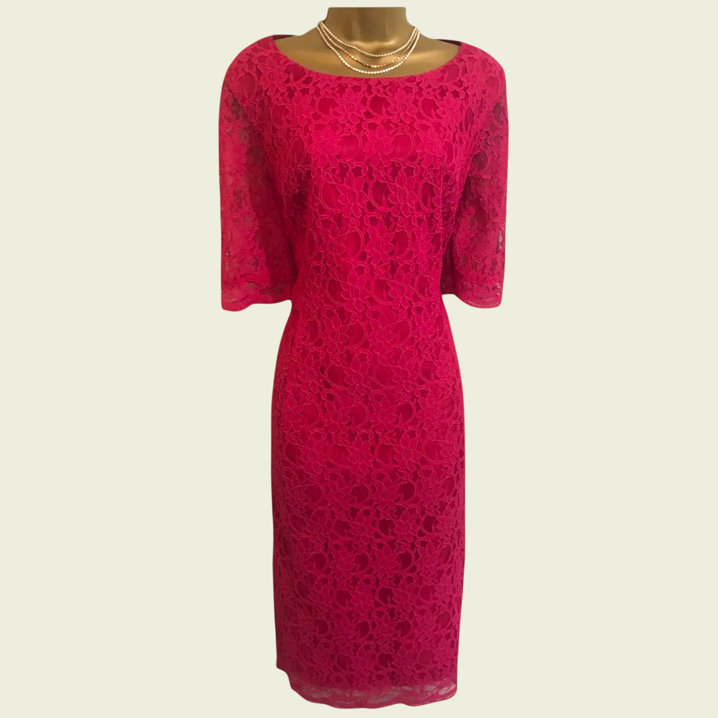 Model wearing pink lace dress on beige background