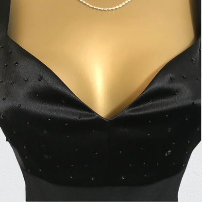 Black satin garment with beads on a mannequin