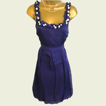 Blue dress with decorative neckline on a mannequin against a beige background