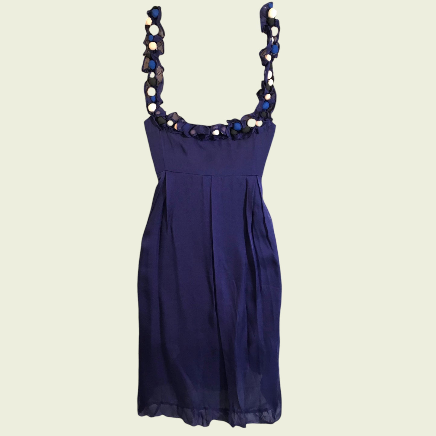 Navy blue dress with decorative straps on a beige background