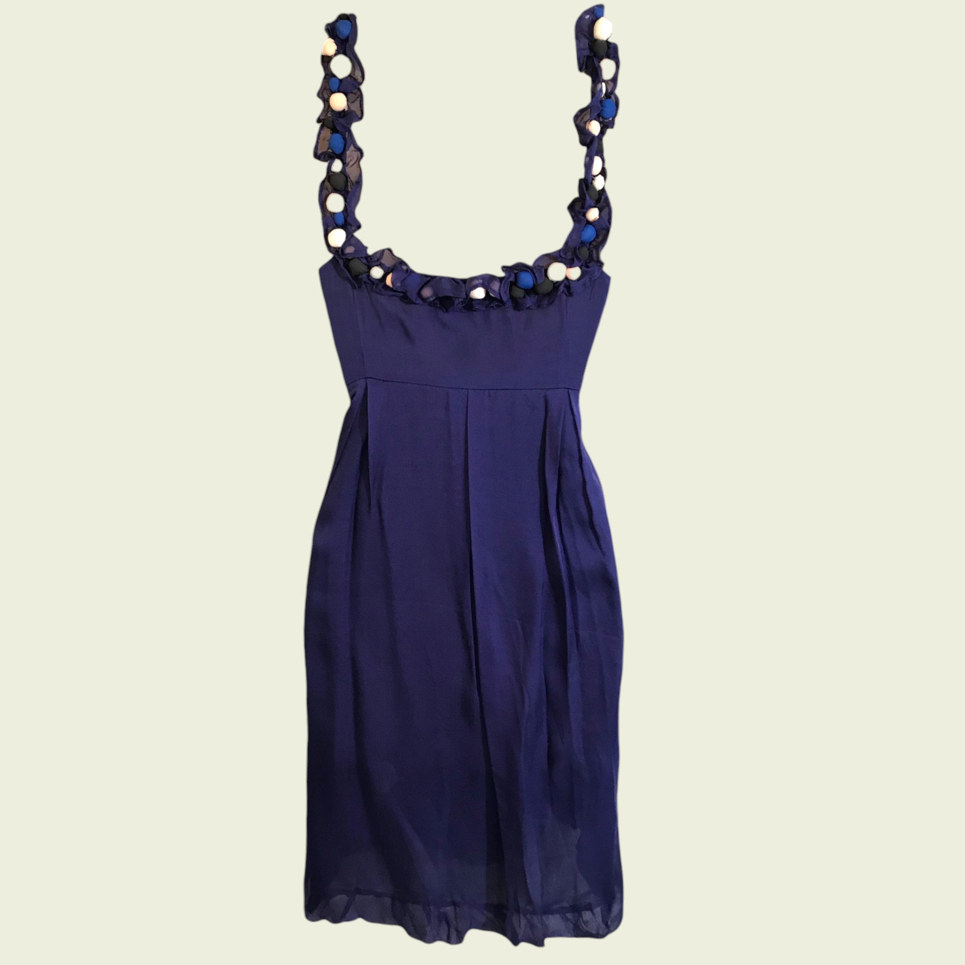 Navy blue dress with decorative straps on a beige background