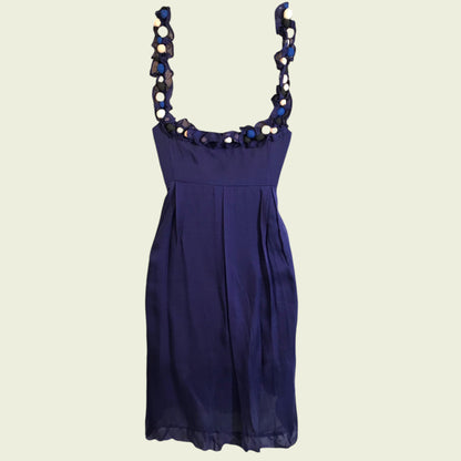 Navy blue dress with decorative straps on a beige background