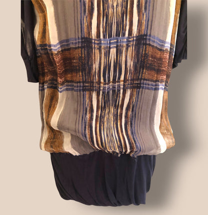 Plaid scarf draped over a black garment on a neutral background