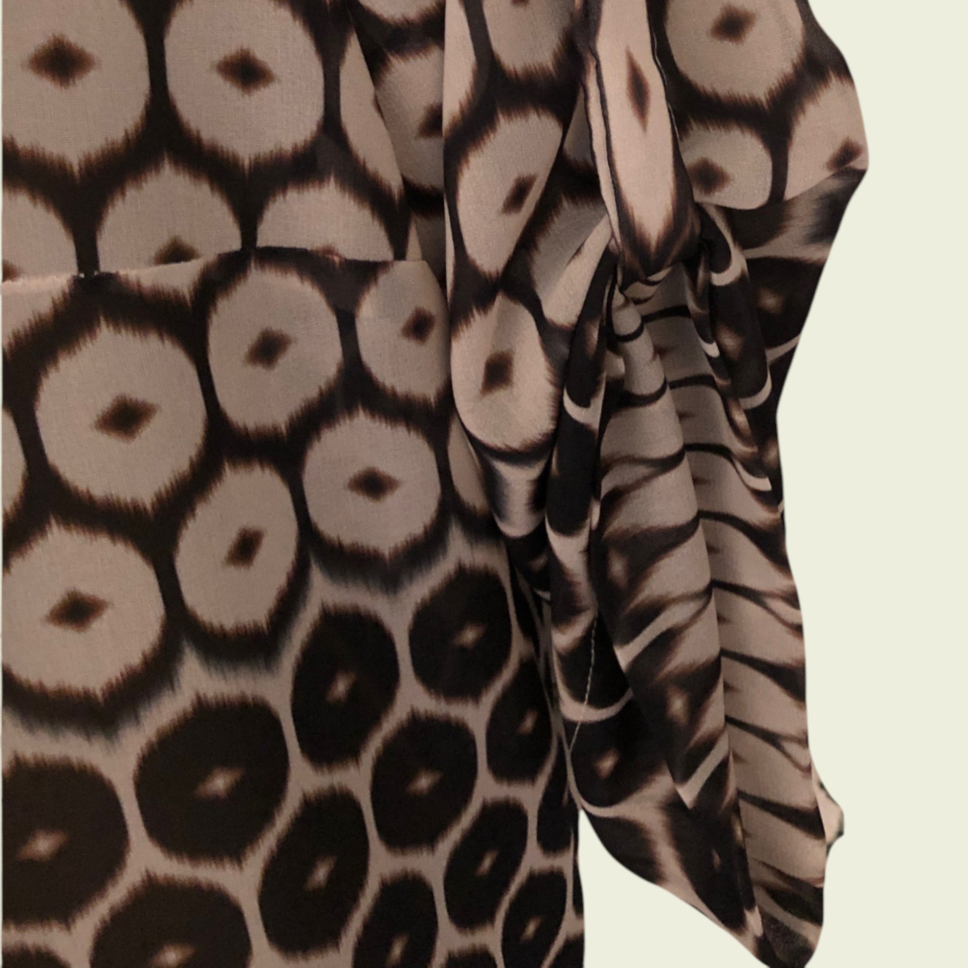 Close-up of fabric with a pattern of circular shapes in brown and beige on a beige background