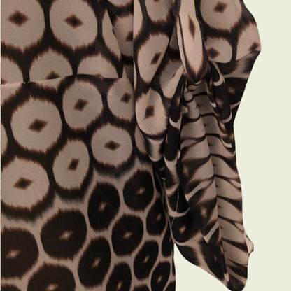 Close-up of fabric with a pattern of circular shapes in brown and beige on a beige background